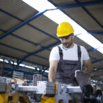 pracownik fabryki obslugujacy maszyne przemyslowa