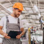 robotnik w magazynie w pomaranczowym kasku