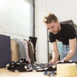 man folding shirt with dots